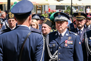 policjant stojący naprzeciw Generała Policji oraz gości honorowych obchodów Święta Policji