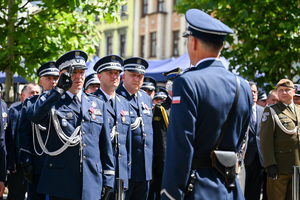 kolorowe zdjęcie Generała Policji oddającego honor, znajduje się w towarzystwie Oficerów Policji
