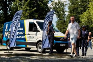 kolorowe zdjęcie umundurowanych policjantów w pobliżu busa promocyjnego policji
