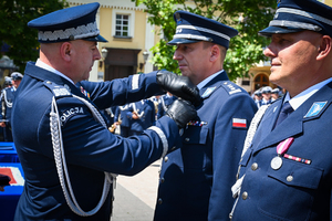 kolorowe zdjęcie przedstawiające zastępcę Komendanta Głównego Policji nadinsp. Rafała Kochańczyka wręczającego oficerom medale