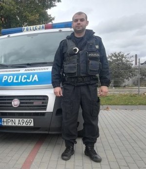 Policjant stojący przed radiowozem