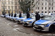 Policjanci z krakowskich komisariatów stoją przy przydzielonych im nowych radiowozach