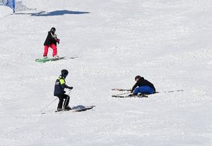 policjant na stoku pomaga narciarzowi który się przewrócił