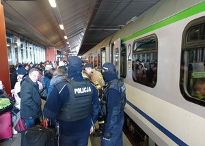 policjanci i czekający na pociąg podróżni na krakowskim dworcu