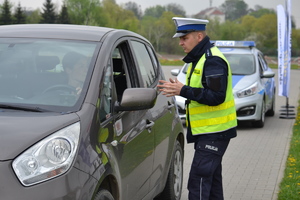 Policjant ruchu drogowego podczas kontroli drogowej przedstawia kierującej powód zatrzymania