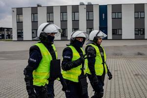 Policjanci z Oddziału Prewencji Policji w Krakowie odgrywający pozoracje, są ubrani w odblaskowe kamizelki