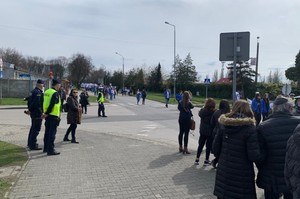 KPP Oświęcim. Marsz Żywych 2023  policjanci zabezpieczają przemarsz. Uczestnicy idą ulicą