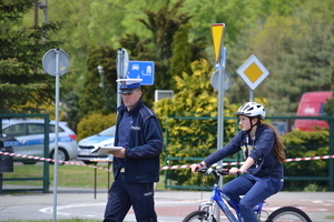 Zawodnik z  policjantem na rowerze na miasteczku ruchu drogowego