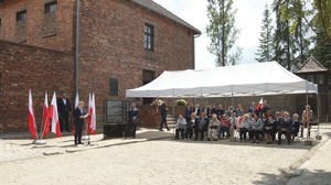 zabezpieczenie 83 rocznica Pierwszego transportu do Auschwitz 14.06.2023  (1) Minister Gliński przemawia na terenie Auschwitz obok namiot, pod którym siedzą byli więźniowie