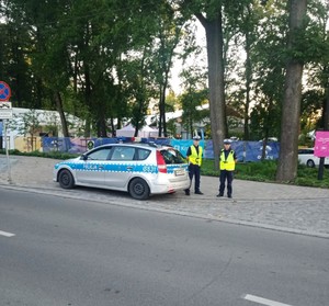 policjanci ruchu drogowego przy radiowozie w rejonie parku