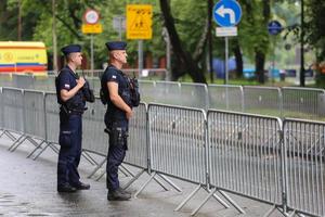 dwóch umundurowanych policjantów stojących przy bramkach zabezpieczających trasę triathlonu