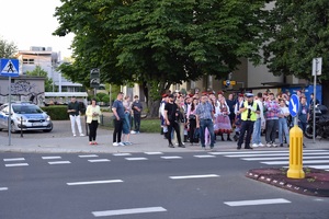 policjant ruchu drogowego kierujący ruchem na jednej z ulic w rejonie stadionu oraz tłum osób znajdujacych się przed przejściem dla pieszych