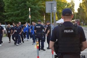 trzech umundurowanych policjantów zabezpieczających przejście zawodników na stadion przy ul. Reymonta