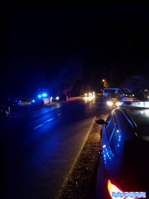 wzdłuż drogi stoją pojazdy policyjne uczestniczące w działaniach poszukiwawczych, zdjęcie nocą