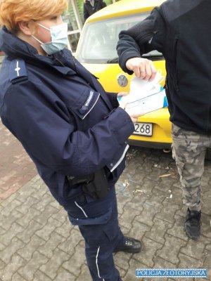 policjantka rozdaje maseczki ochronne