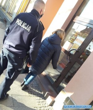 policjant z pracownica sanepidu wchodza do sklepu