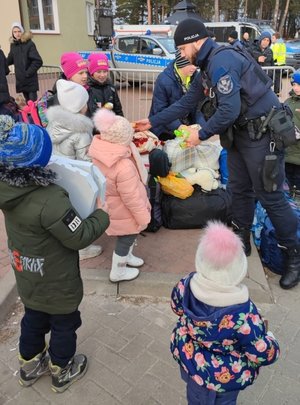 policjant rozdaje dzieciom jedzenie