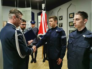 po lewej stronie podinspektor Dariusz Wesołowski wręcza akt mianowania policjantom