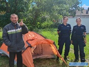Policjantki stoją obok pomarańczowego namiotu, z drugiej strony namiotu stoi mężczyzna