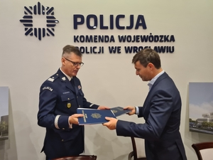 Komendant Wojewódzki Policji we Wrocławiu i przedstawiciel firmy stoją wraz z podpisaną umową na budowę nowego komisariatu