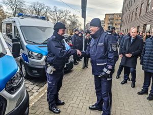 Komendant Wojewódzki Policji we Wrocławiu nadinspektor Dariusz Wesołowski przekazuje policjantowi klucze go nowego radiowozu.