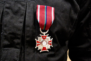 Na zdjęciu medal w kształcie krzyża, który otrzymali funkcjonariusze Samodzielnego Pododdziału Kontrterrorystycznego Policji we Wrocławiu uczestniczący w misji humanitarnej w Ukrainie.