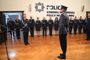 uroczystość w sali w której stoja policjanci w mundurach