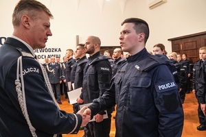 Komendant Wojewódzki policji wrecza akty ślubowania nowym policjantom