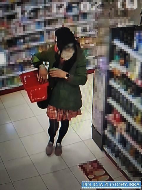 Zdjęcie z kamery sklepowej przedstawiające mężczyznę przebranego za kobietę, chodzącego pomiędzy regałami sklepowymi.