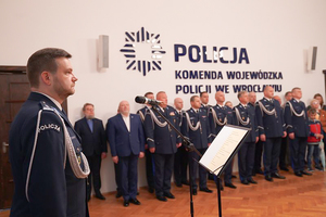 Na zdjęciu na pierwszym planie Zastępca Komendanta Wojewódzkiego Policji inspektor Norbert Kurenda stojący przy mikrofonie w tle kadra kierownicza dolnośląskiej policji.