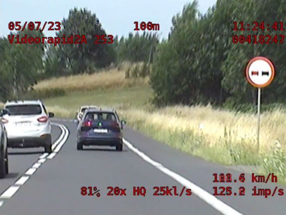 Zdjęcie z fotoradaru przedstawiające jak dwa pojazdy osobowe wyprzedzają w niedozwolonym miejscu i bez zachowania dozwolonej odległości między samochodami.