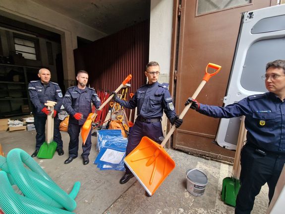 policjanci noszą pomoc humanitarną