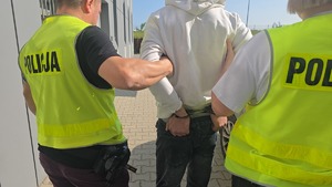 policjanci prowadzą zatrzymanego