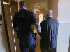 policjant prowadzi zatrzymanego mężczynę