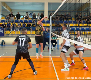 mężczyźni podczas gry w siatkówkę na hali sportowej