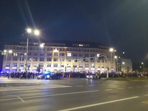Widok na tłum ludzi na pl. Solidarności we Wrocławiu i zabezpieczające radiowozy.