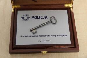 Na zdjęciu tabliczka z napisem POLICJA, otwarcie komisariatu w Bogatyni 17 grudnia 2020 rok. Na tabliczce leży klucz.