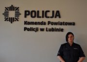 Na zdjęciu dzielnicowa Małgorzata Merena na tle napisu Komenda Powiatowa w Lubinie.