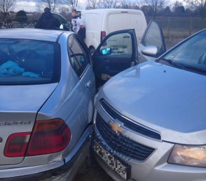 Dwa samochody osobowe zaparkowane blisko siebie. Oba są lekko uszkodzone w wyniku kolizji. W tle trzeci pojazd.