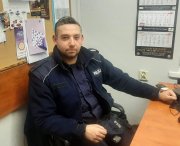 policjant w mundurze siedzący przy biurku w komendzie