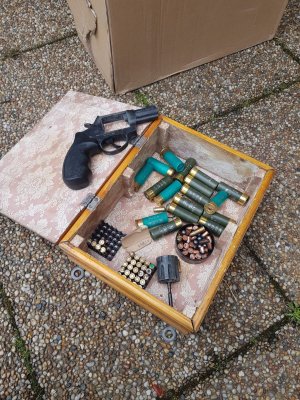 Zabezpieczona broń i amunicja w pudełku.
