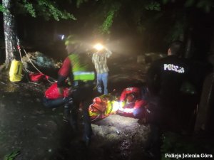 Na zdjęciu widać jak ratownicy GOPR i policjanci pomagają poszkodowanemu turyście