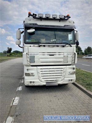 Zdjęcie przedstawia przód pojazdu ciężarowego koloru białego