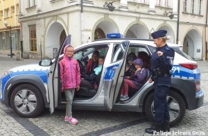 Dzieci oglądają radiowóz wraz z policjantką