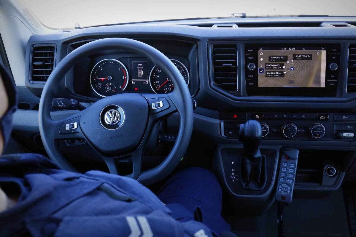 Kokpit Volkswagena Craftera. W pierwszym planie za kierownicą siedzi policjant