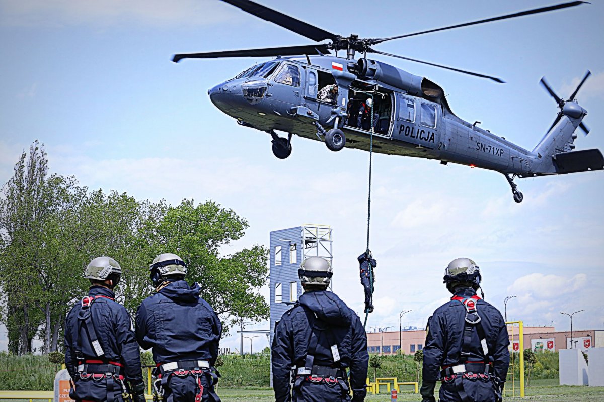 lecący helikopter, pod nim na linie wiszą kontterroryści