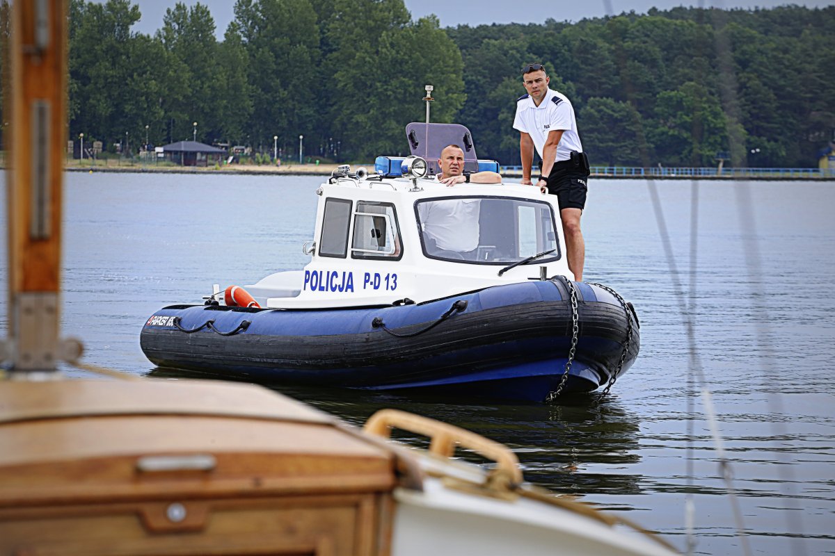Policyjni wodniacy na łodzi motorowej.