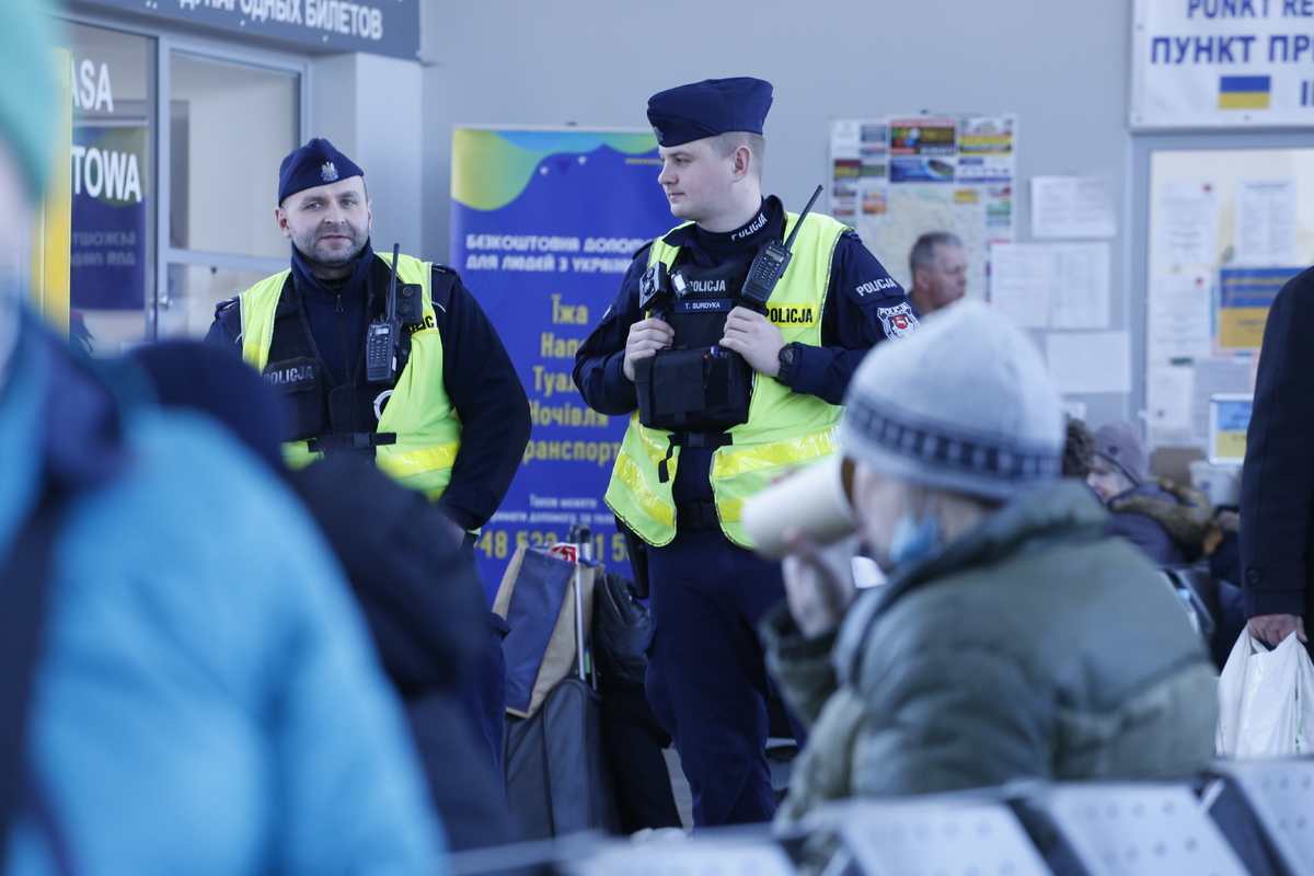 patrol polici w hali z uchodźcami 