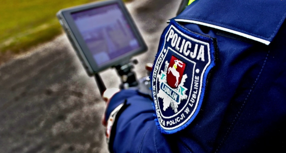 Policjant rzyma panel sterujący dronem.