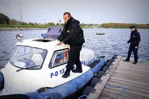 policjant na łodzi, drugi - na brzegu